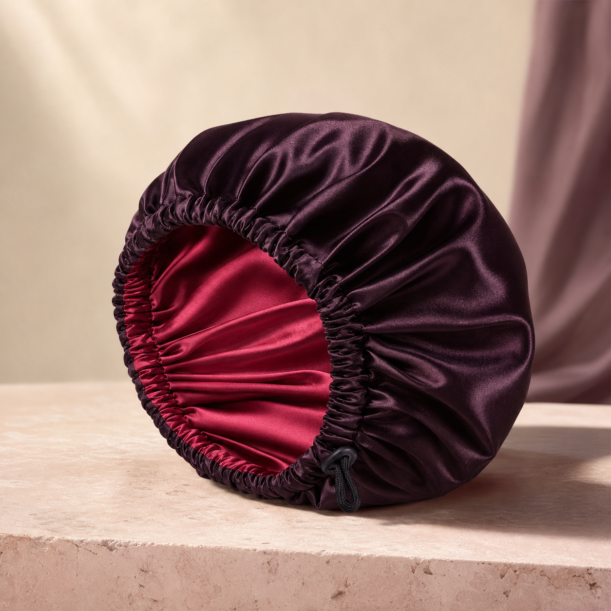 SatinCloud Adjustable Bonnet photographed on a warm ivory and blush studio backdrop