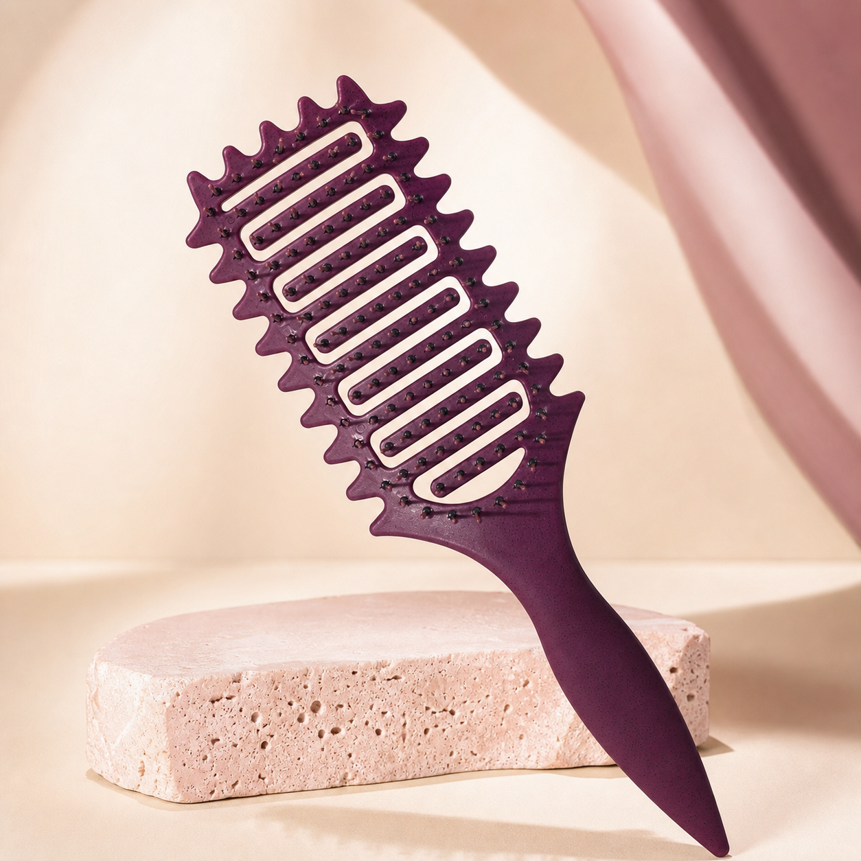 FlexCurl Detangling Brush photographed on a warm ivory and blush studio backdrop